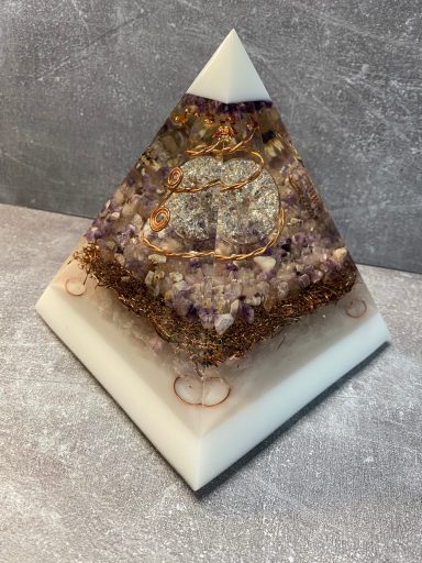 Pyramide aus Harz mit glitzernden Kristallen und einem geometrischen Muster auf der Oberfläche.