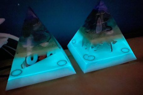 Zwei leuchtende Pyramiden mit bunten Unterwasserfiguren und Wasserblasen.